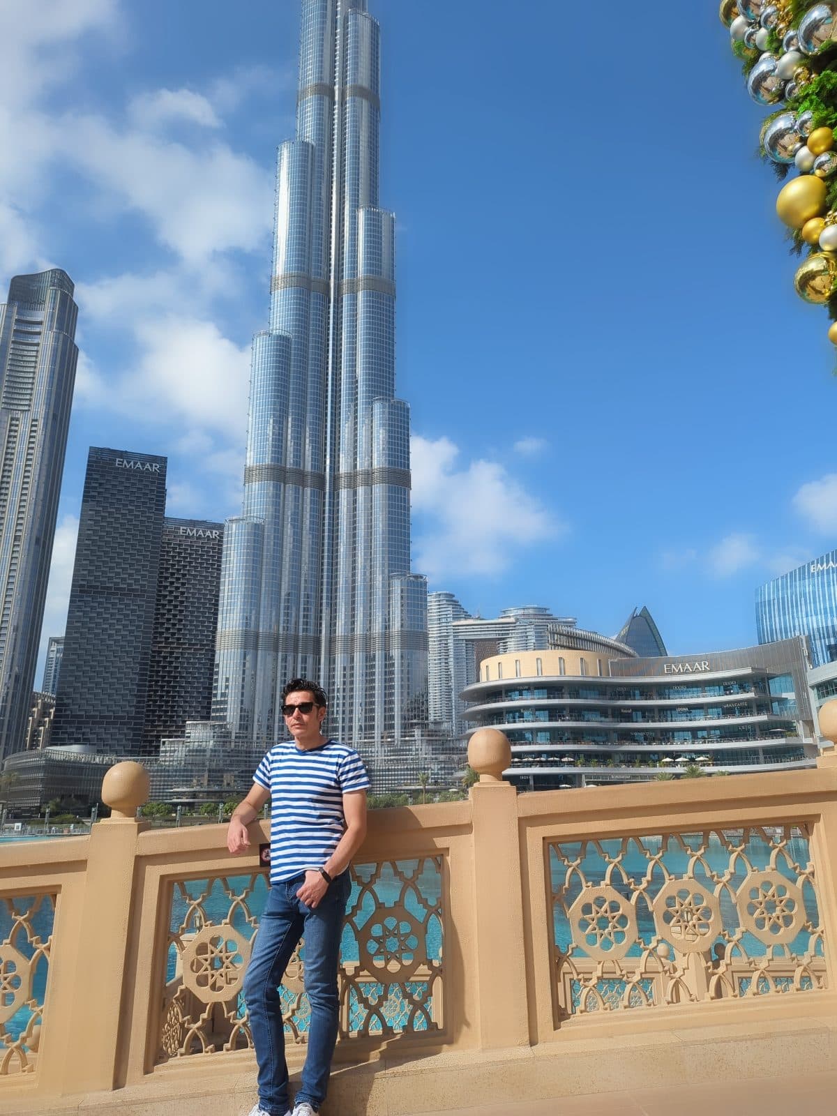 Standing on the Burj Khalifa boulevard next to Dubai Mall, with the tower's full height visible behind