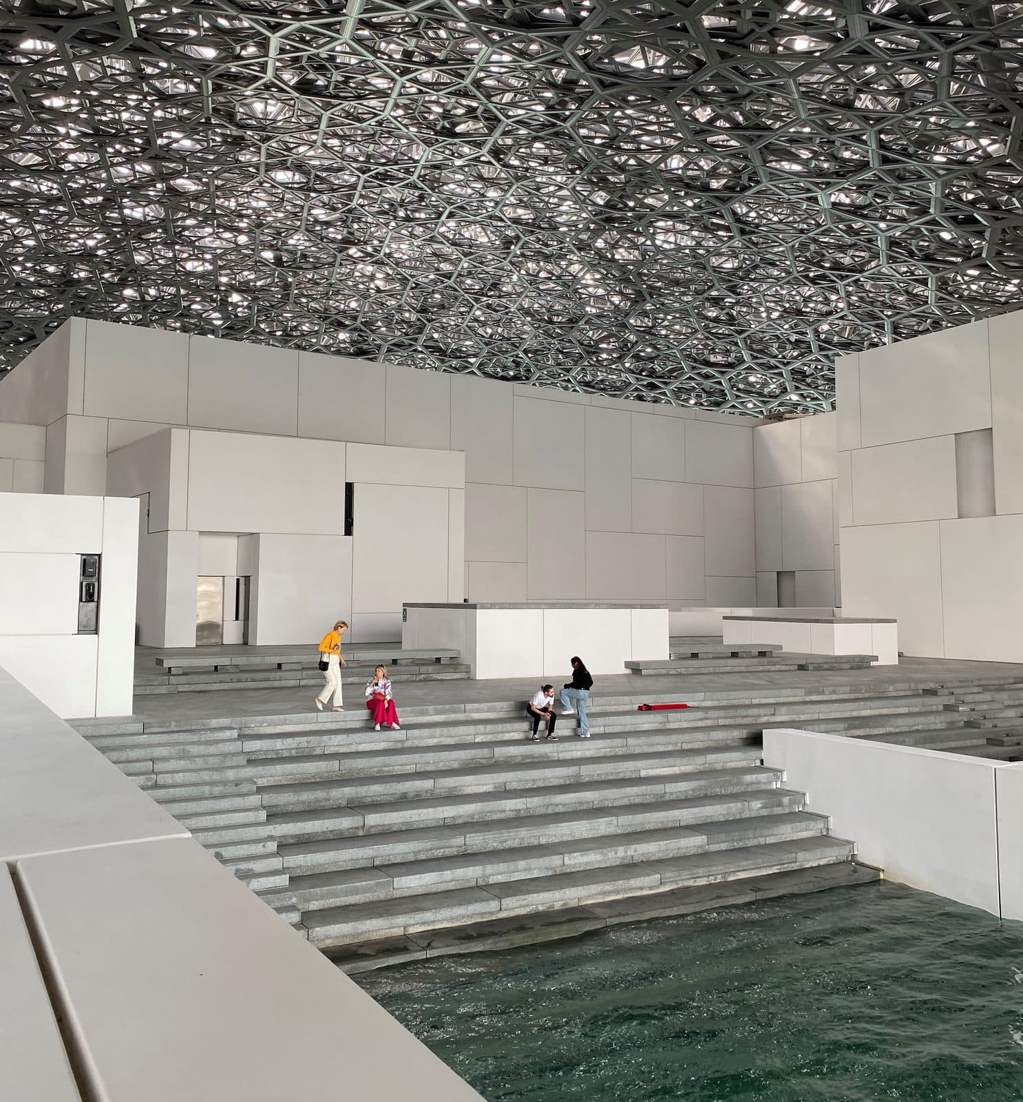 Sunlight filtering through Louvre Abu Dhabi's dome onto the courtyard below